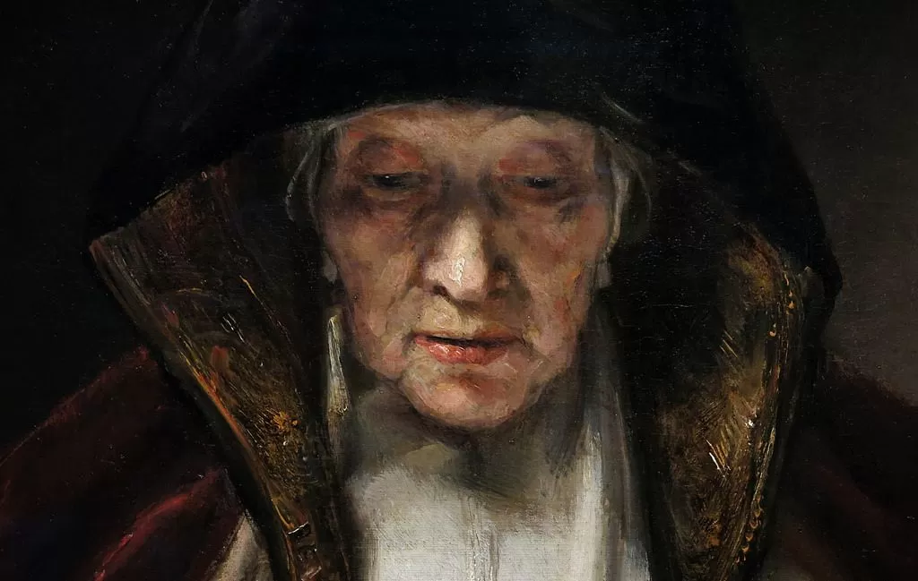 Detail from Rembrandt's 1655 painting of an old woman reading, showcasing masterful depiction of human character